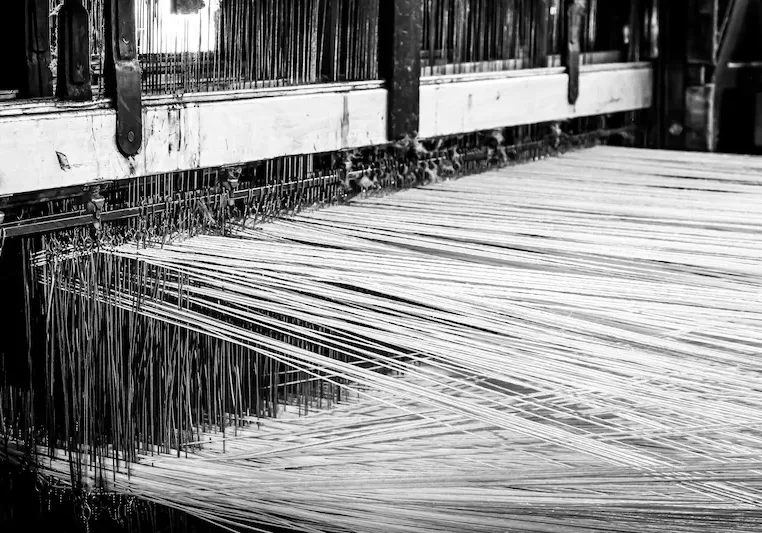 Close-up of a loom weaving wires with a machine A close-up of a loom weaving wires with a machine